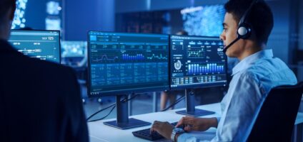 Person in a NOC looking at data dashboards.